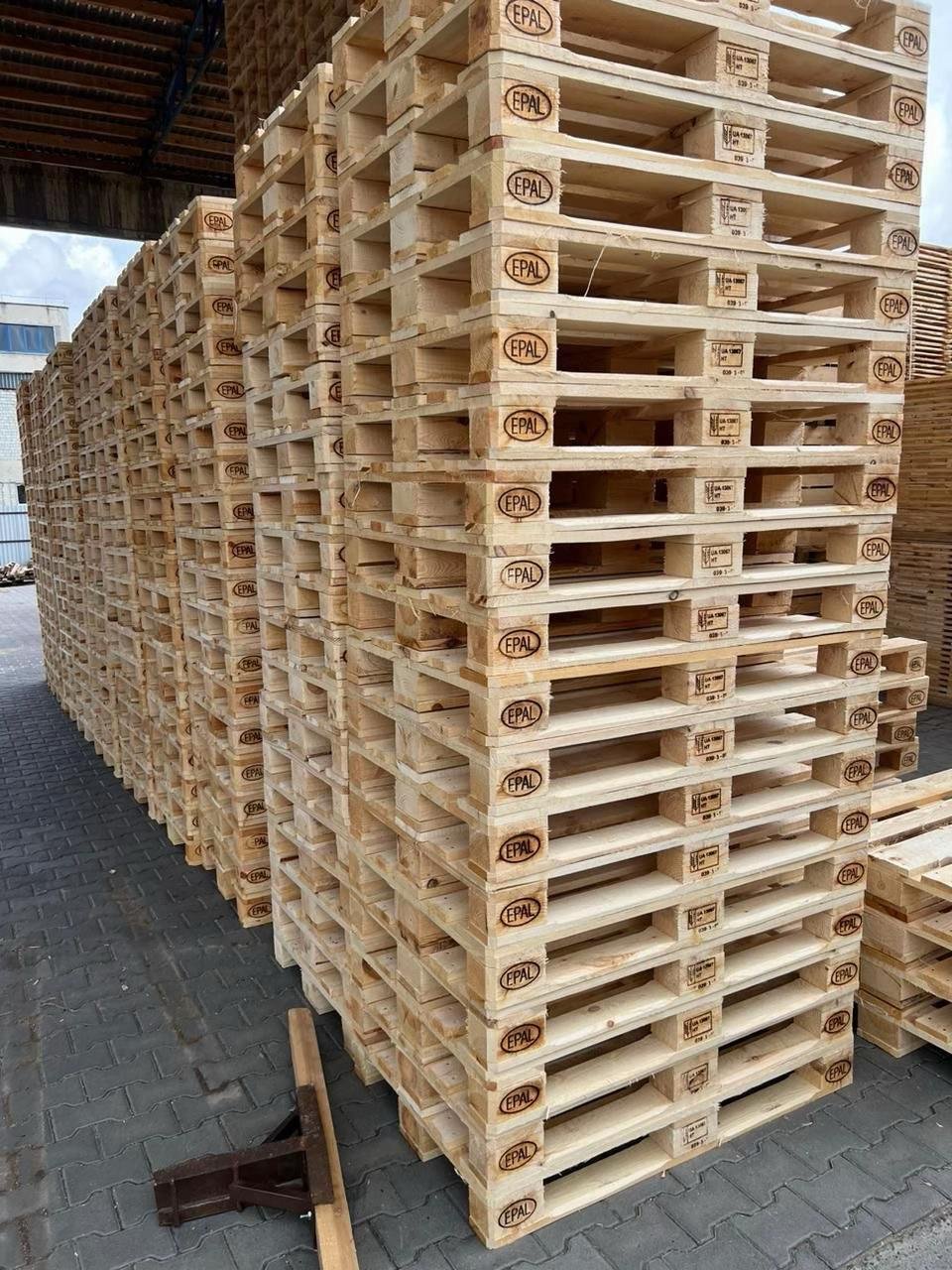 Tall stacks of wooden pallets with visible markings
